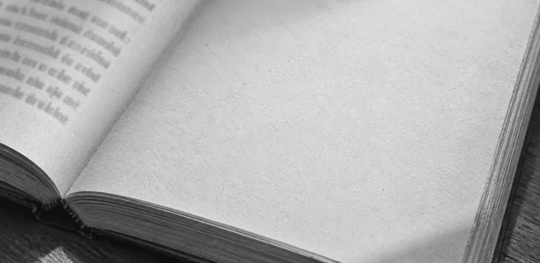 A close view of the paper and pages of a printed book.